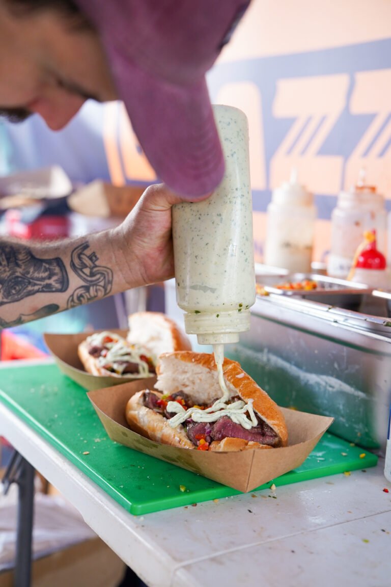 Pouring mayo over Brazilian BBQ roll
